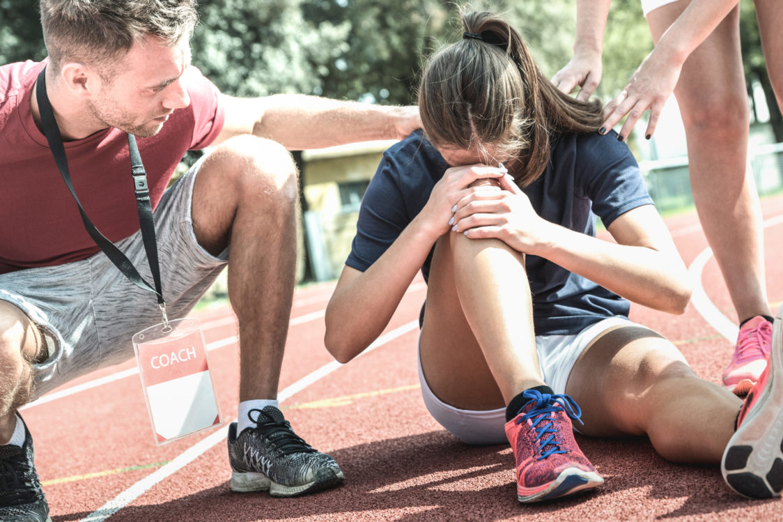 What is the first aid for a strained or torn muscle?